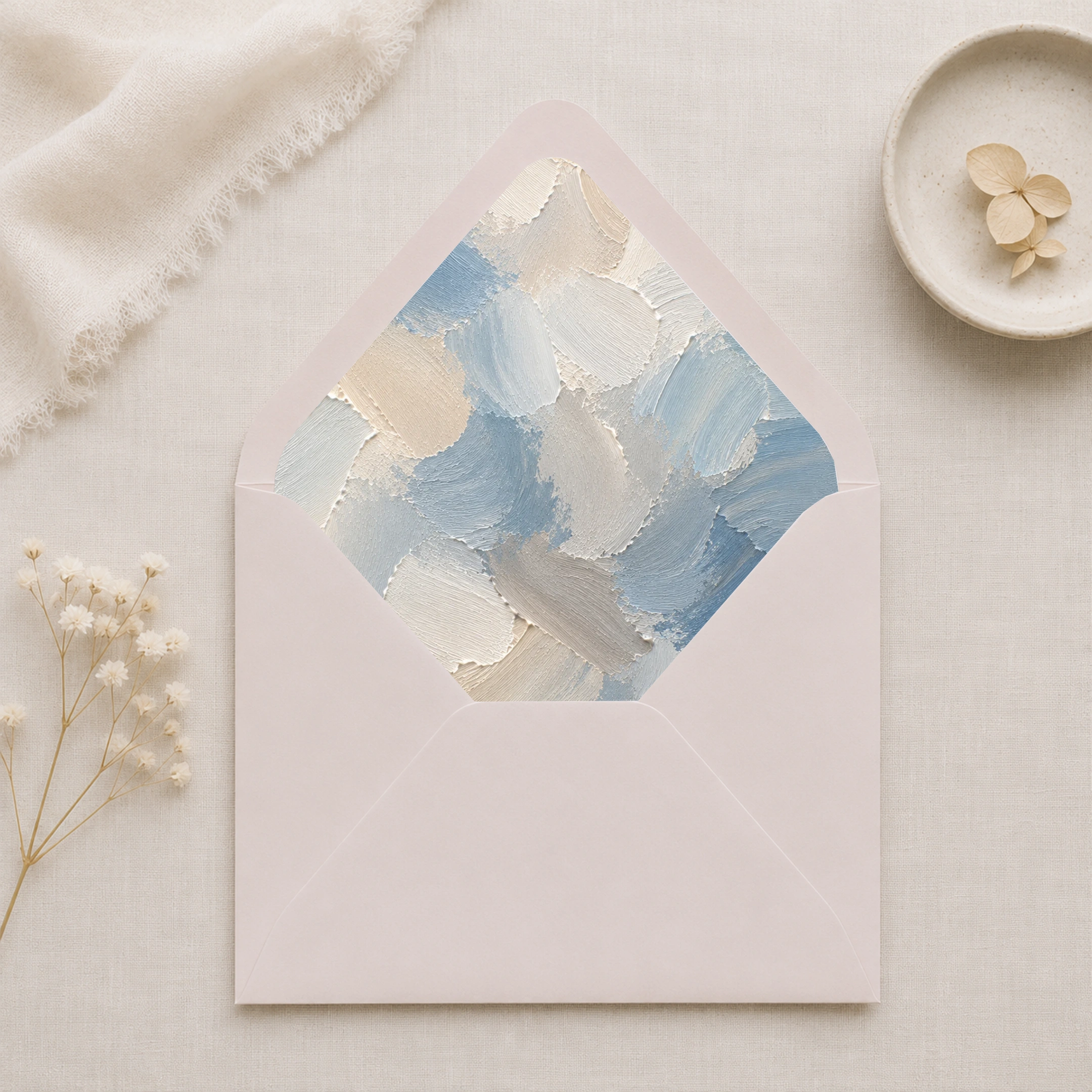 Dusty Canvas Envelope Liner Template displayed inside a soft taupe envelope, featuring abstract dusty blue, ivory, cream, and warm grey painterly brushstrokes for elegant wedding invitations.